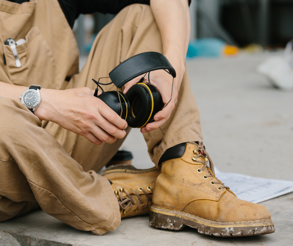construction worker sitting holding headphones